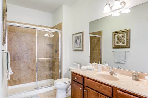 A bathroom with a toilet, sink, and shower.