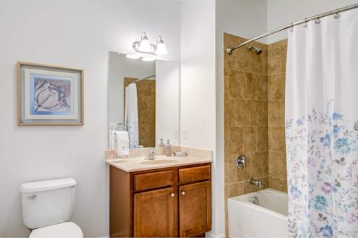 A bathroom with a toilet, sink, and shower.