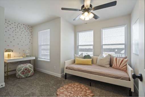 A bedroom with a bed, a window, and a ceiling fan.