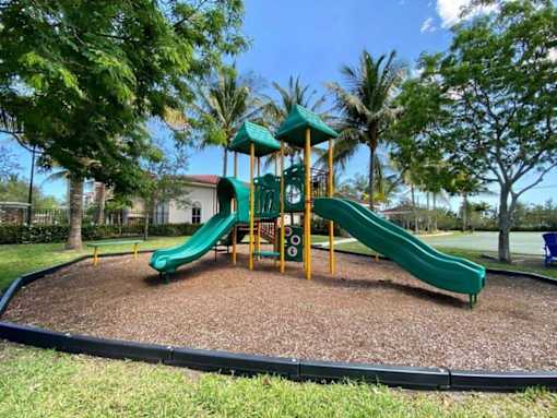 A playground with a green slide and a yellow structure.