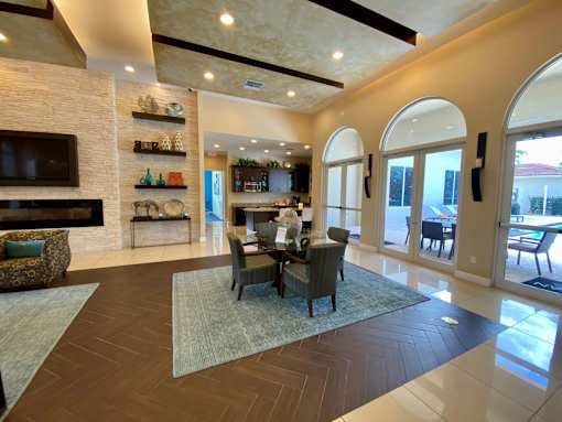 A large, well-lit living room with a dining table and chairs.