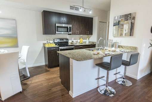 A kitchen with a bar stool and a counter.