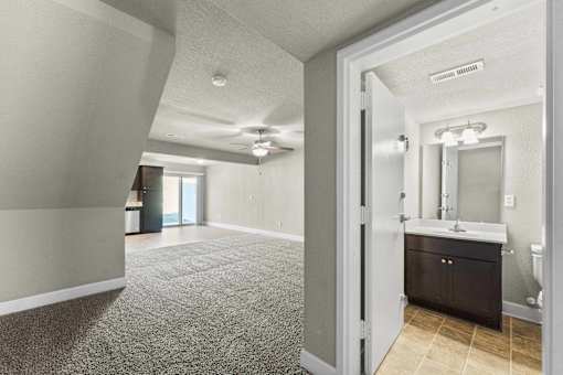A bathroom with a sink, mirror, and toilet is shown.
