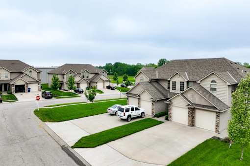 A white car is parked in front of a house in a residential neighborhood.