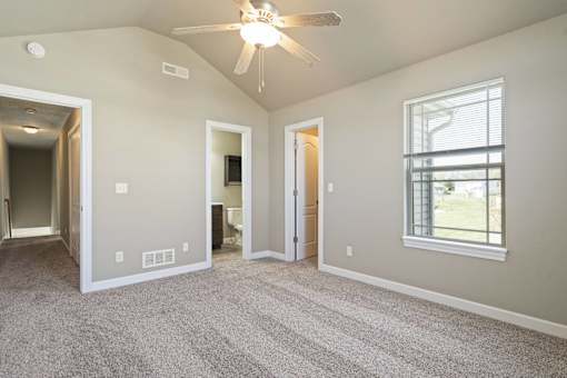A room with a ceiling fan and a window.
