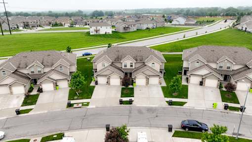 A suburban neighborhood with houses and a car parked on the street.