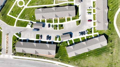 A parking lot with cars and a building in the background.