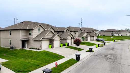 A row of houses with a red fire hydrant in front of the first house.