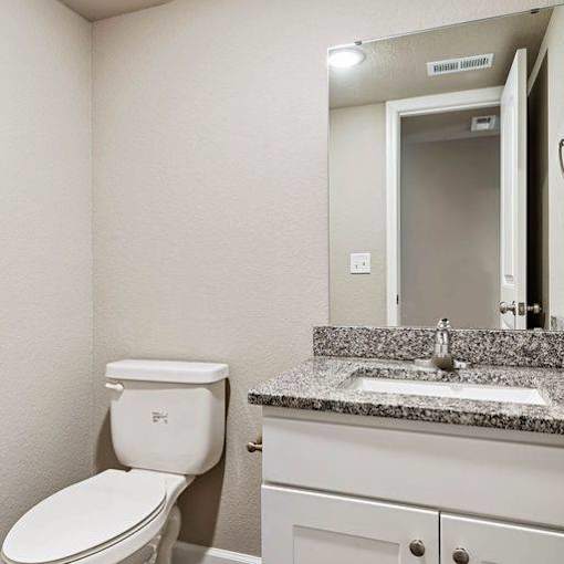 A white toilet sits next to a sink in a bathroom.