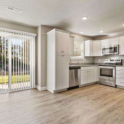 A modern kitchen with white cabinets and stainless steel appliances.