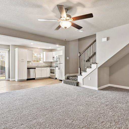 A spacious living room with a staircase leading to the upper floor.
