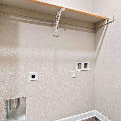 A white wall with a shelf and two electrical outlets.