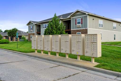 A long row of mailboxes in front of a building.