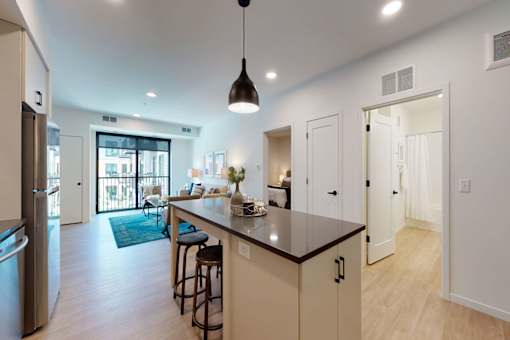 A kitchen with a bar and a refrigerator.