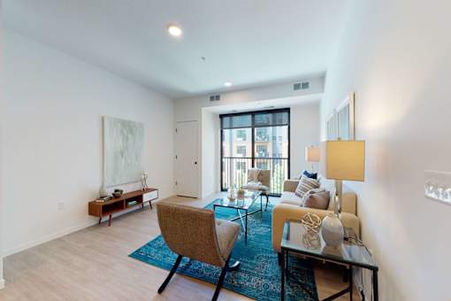 A living room with a blue rug and a brown chair.