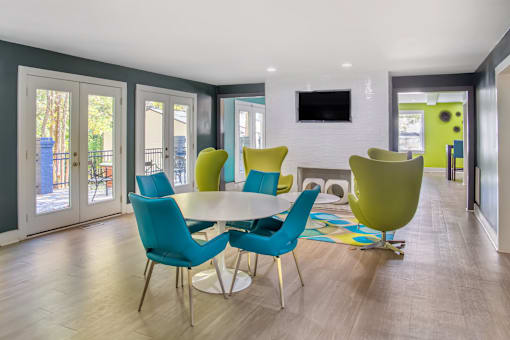 A modern dining room with a white table and blue chairs.