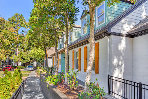 A row of houses with green shutters and white walls.