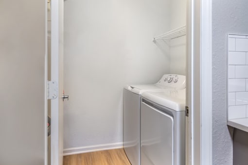 A small white fridge in a narrow room.