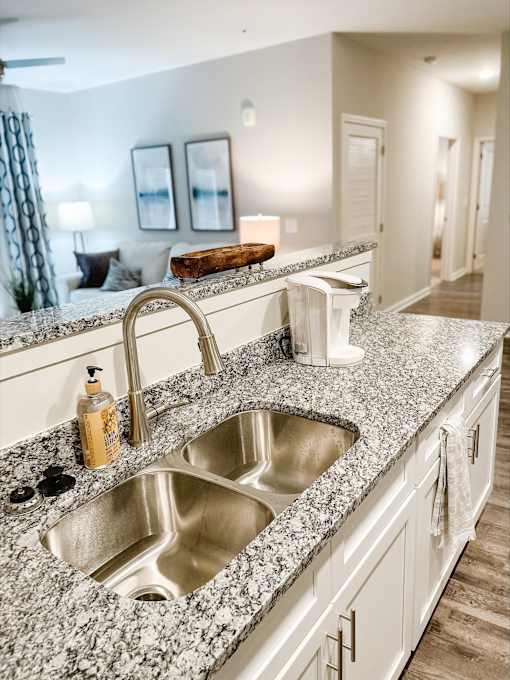 A kitchen with granite countertops and a stainless steel sink.