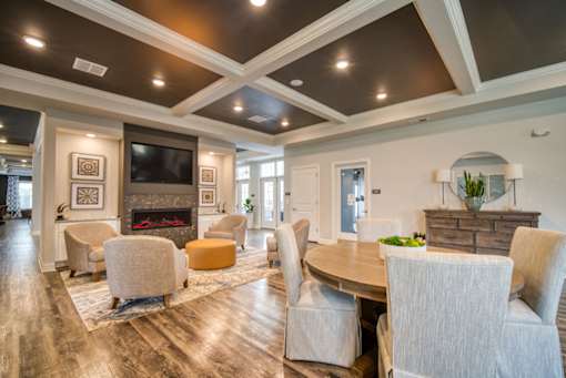 A living room with a fireplace and a TV on the wall.