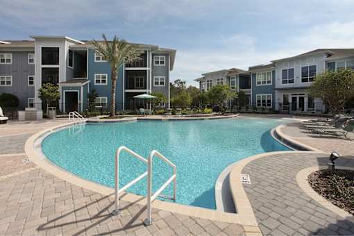 A swimming pool in front of apartment buildings.