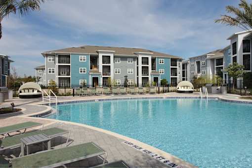 A swimming pool in front of apartment buildings.