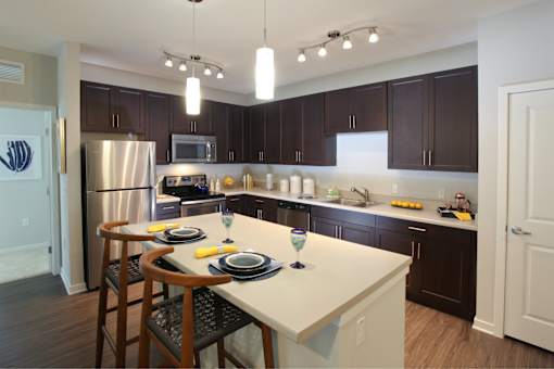 A kitchen with brown cabinets and a white island.
