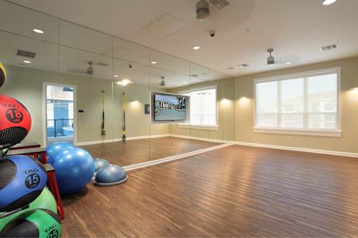 A room with exercise balls and a mirror on the wall.