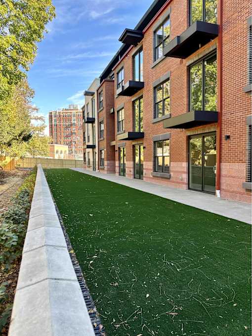 A long building with a green lawn in front.