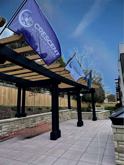 A Crescent Atraviesh banner hangs from a wooden pergola.