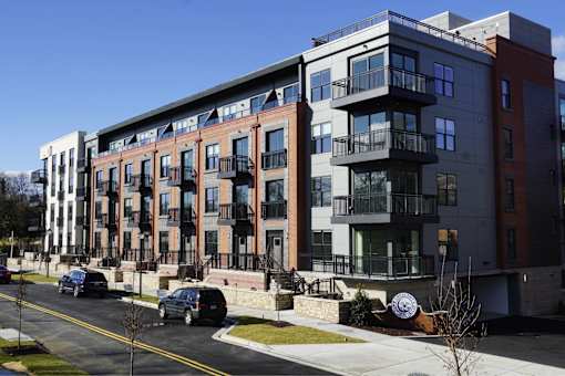 A modern apartment building with balconies and multiple stories.