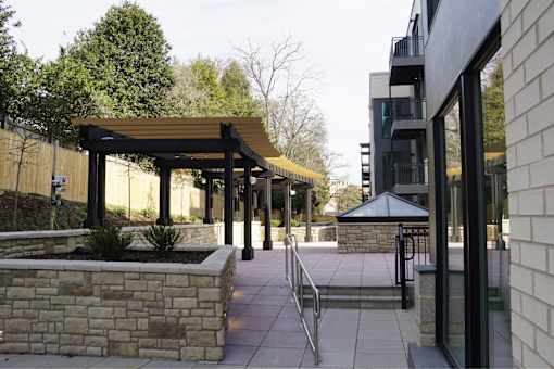 A building with a black awning and a stone wall.