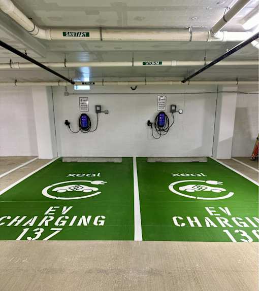 Two EV charging stations are located in a parking garage.