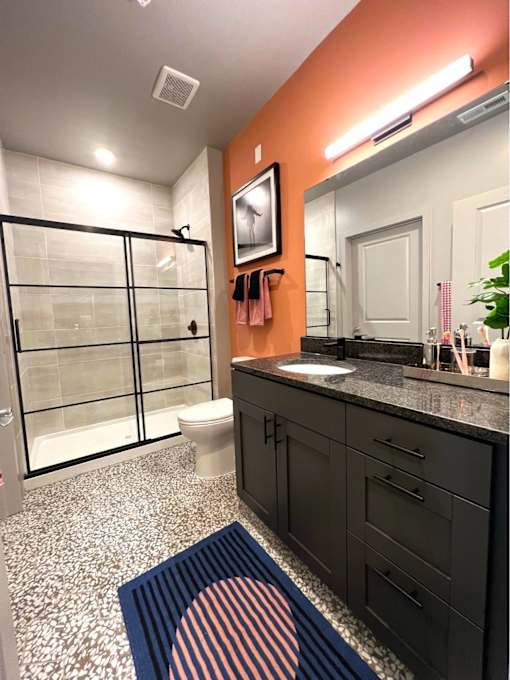 A bathroom with a toilet, sink, and mirror.