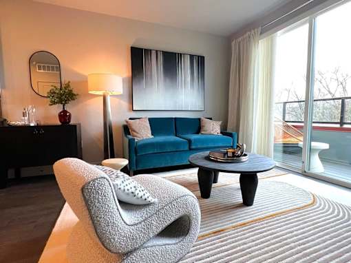 A modern living room with a blue sofa and a grey armchair.