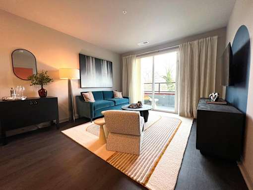 A living room with a blue couch and a white chair.