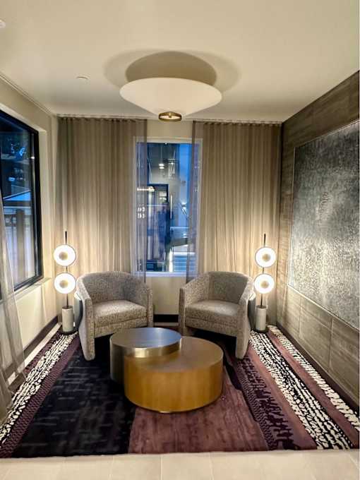 A room with a round table and two chairs with lights on the side.