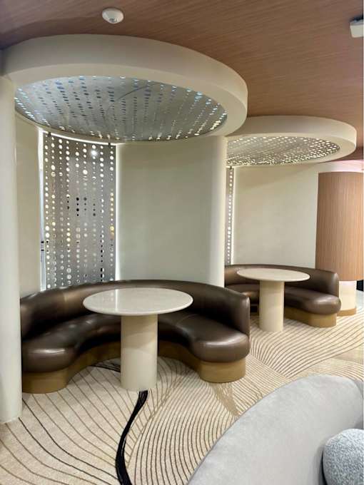 A modern room with a white table and brown chairs.
