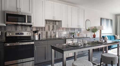 A modern kitchen with a dining table set for two.