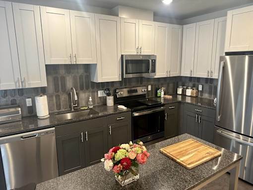A kitchen with a granite countertop and a vase of flowers on it.