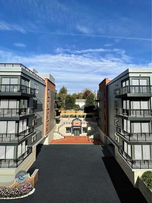 A courtyard between two buildings with a bench and a planter.