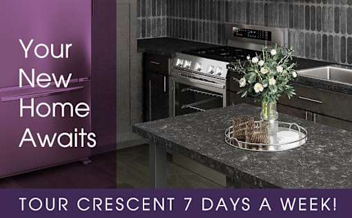 A kitchen with a modern design featuring a stove and a counter with a vase of flowers on it.