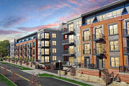 A street view of a row of modern apartment buildings.