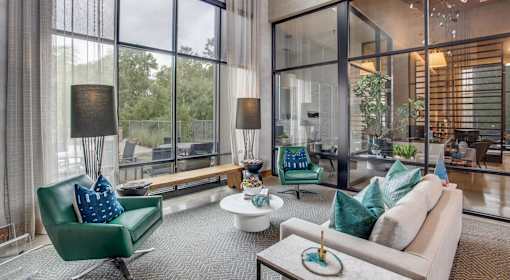 A modern living room with a green chair and a white couch.
