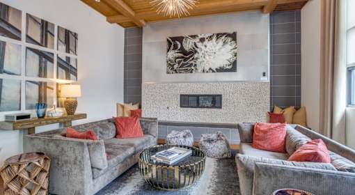 A living room with grey couches and a fireplace.