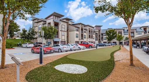 A row of cars parked in front of apartment buildings.