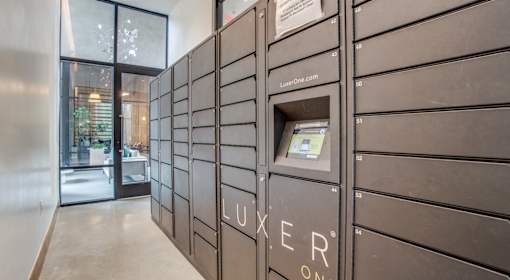 A row of Luxeer One mailboxes are lined up on a wall.
