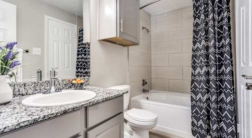 A bathroom with a white toilet, sink, and bathtub.