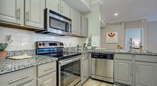 A modern kitchen with a stove, oven, and microwave.