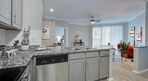 A modern kitchen with granite countertops and stainless steel appliances.